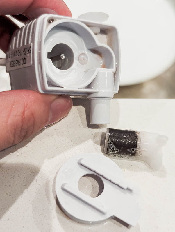 Pet fountain pump with cover and rotor impeller removed for cleaning.